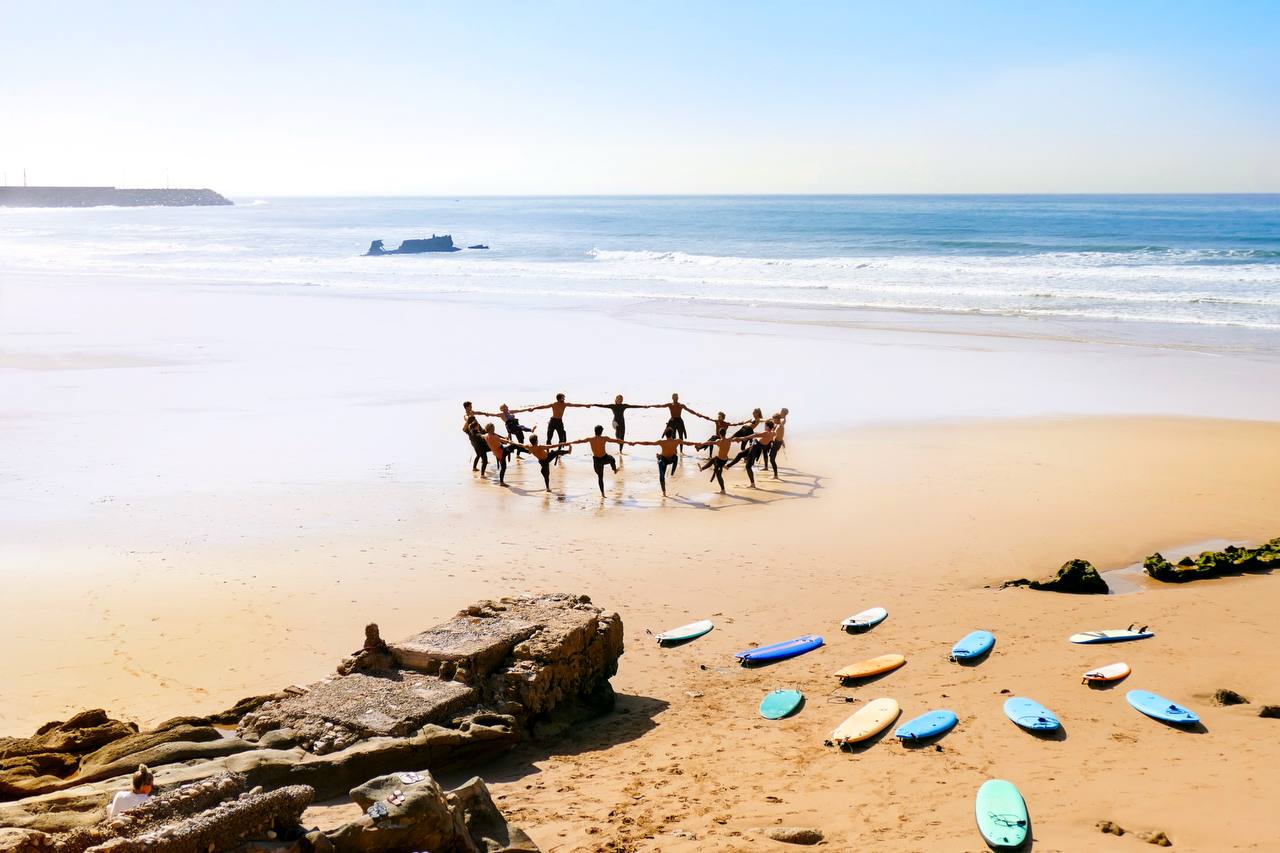 Surf camp group warming up on the beach before a lesson