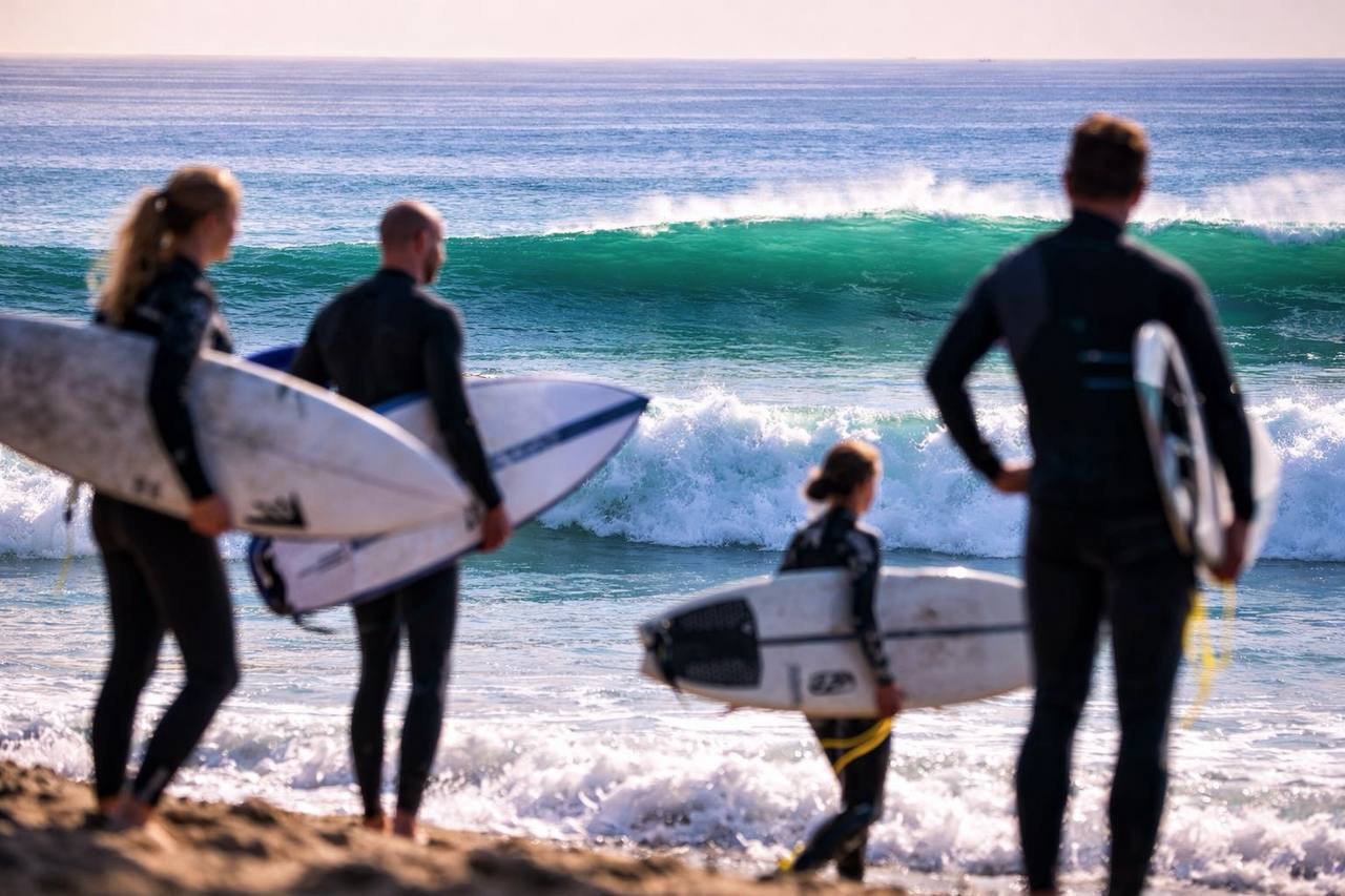 Four surfers entering the waves during the Ripstar surf coaching trip in Morocco