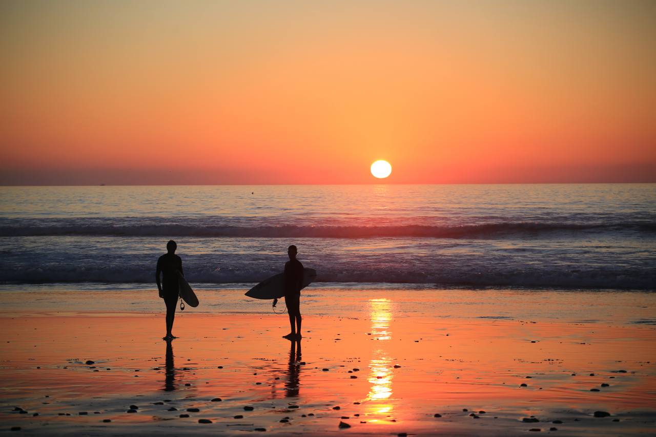 Two surfers at sunset on the beach near Agadir Morocco