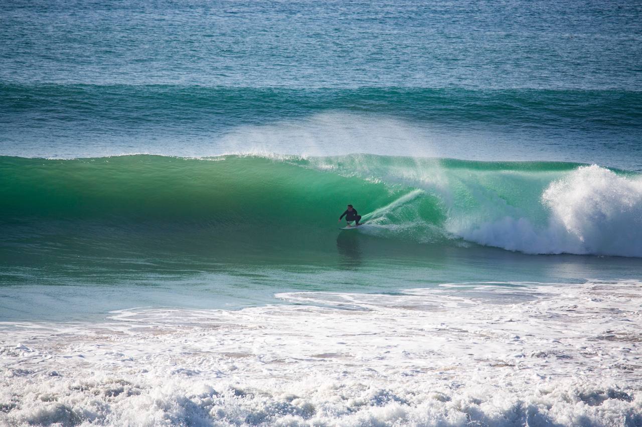 Surfer scouting a rocky point and checking the waves
