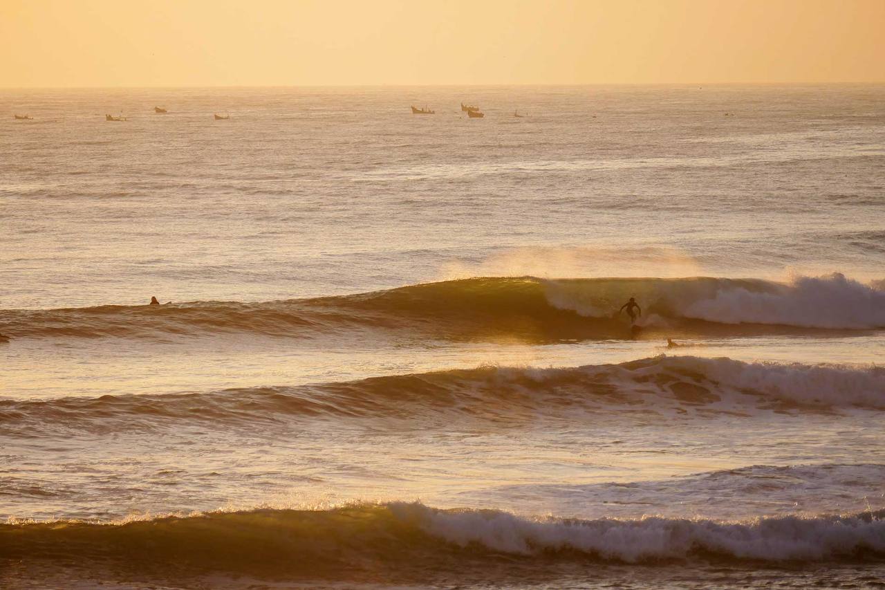 Surfers and warm evening light near the Taghazout coastline