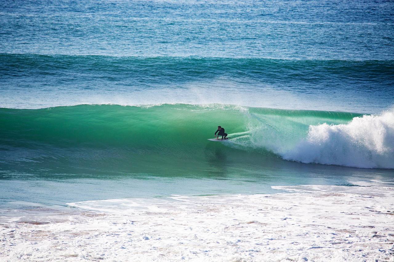 Surfer riding a barrel wave in Taghazout, Morocco